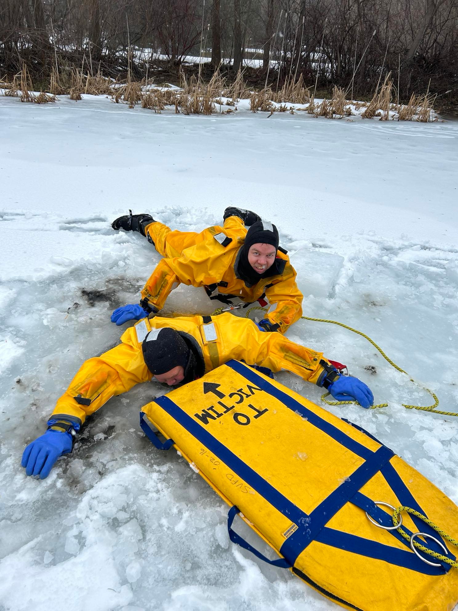 Ice rescue training - rescuers practicing sled extraction on ice